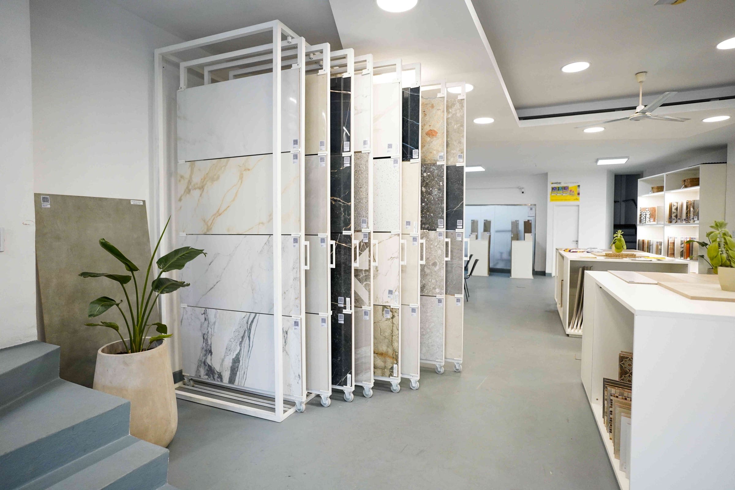 Pasillo del showroom con exhibidores de porcelanatos símil mármol